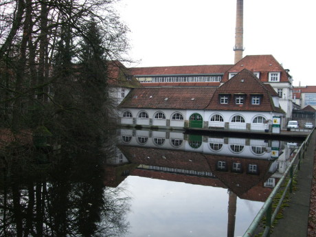 Gebäude vor Wasseranlage und Bäumen